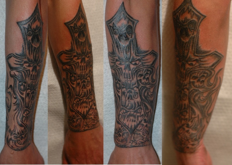 cross tattoos for men on arm. Cross with skull faces.